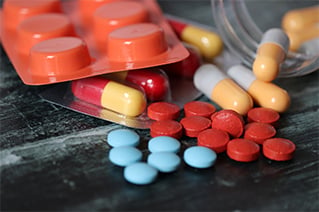 colorful pharmaceuticals spilled on a black table