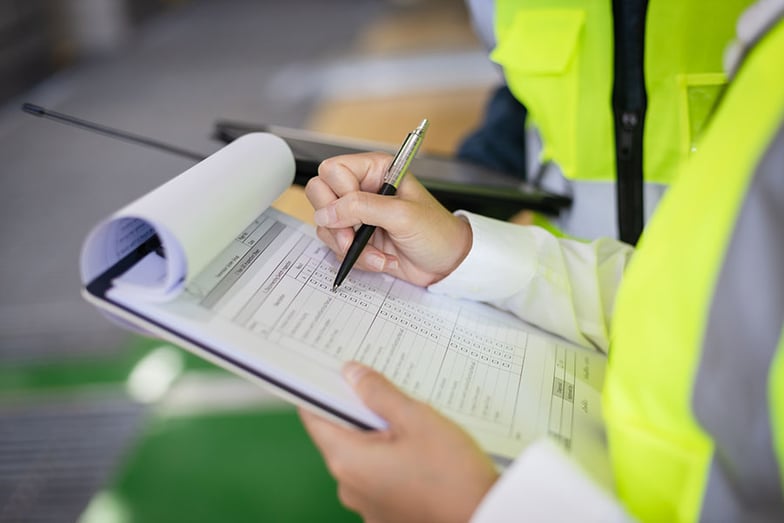 woman writing on clipboard