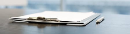 Open notebook and paper on a desk in soft light
