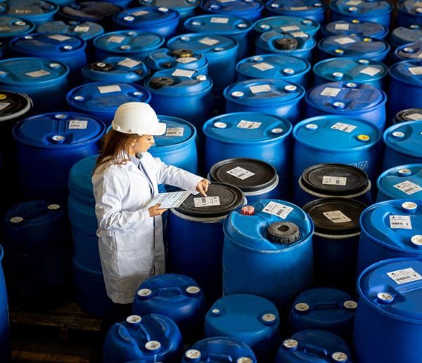 woman ensuring waste drums are compliant