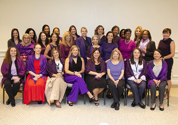 Large group of Reworld employees dressed in purple posed together at an Employee Resource Group event