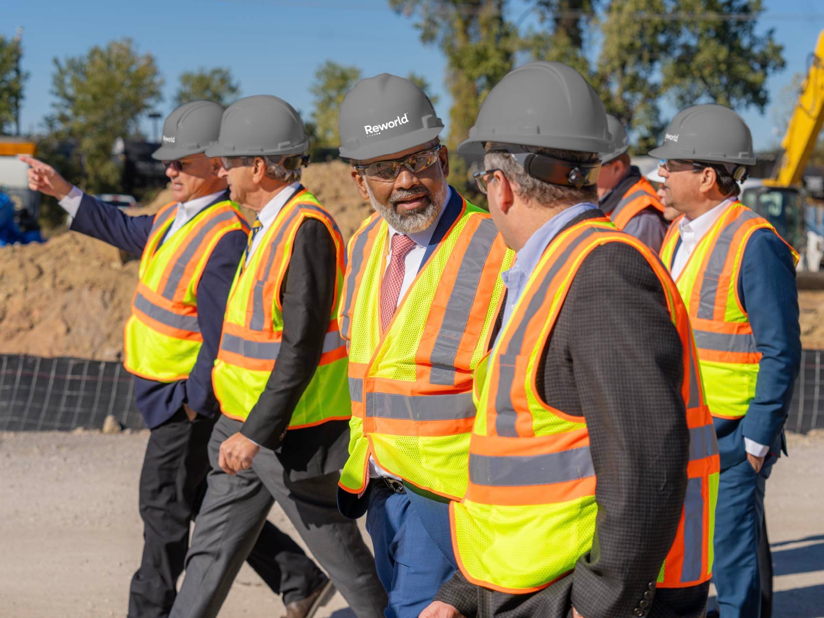Reworld leaders in hard hats and high-visibility vests touring an active construction site