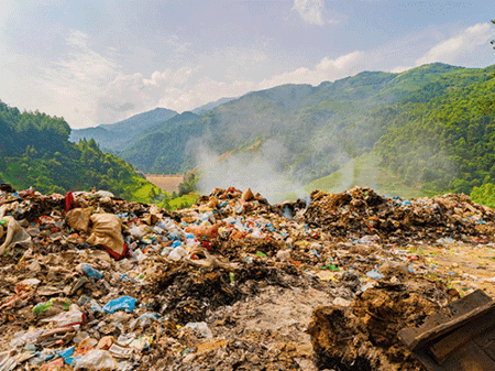 Open landfill site in a green mountain valley