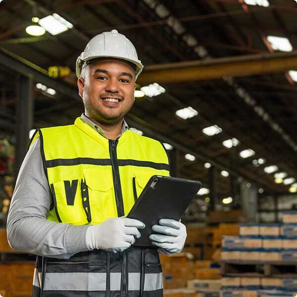 Waste worker holds clipboard as he prepares to work with broker partner.