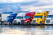 Different colored tractor-trailers for cargo transportation.