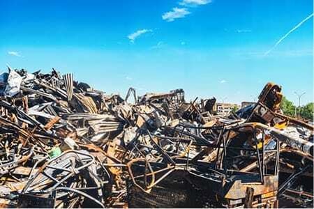 Large pile of scrap metal collected for recycling at an industrial yard.