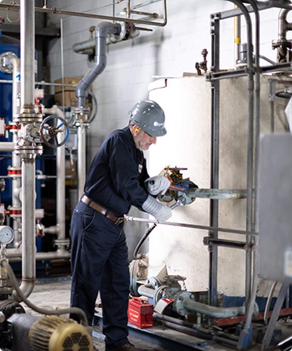 Reworld employee works on equipment.