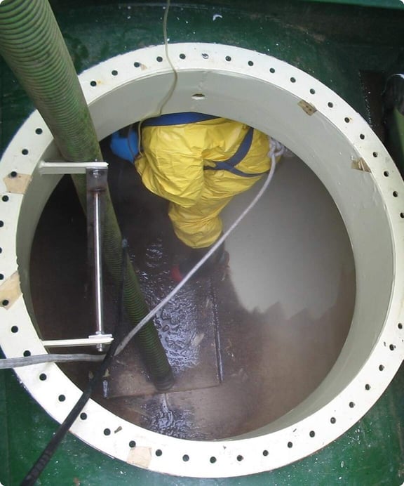 Worker enters confined space to perform industrial cleaning service.