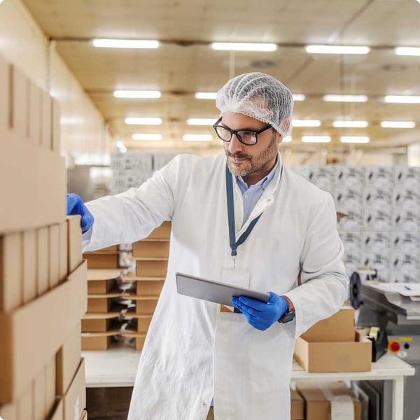 Pharmaceutical facility worker examines waste material.