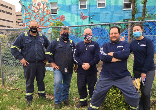 Covanta employees pose at garden
