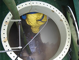 a Covanta Environmental Solutions employee cleaning in a confined space