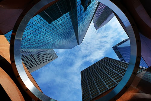 looking up at a blue sky and buildings from a circular perspective