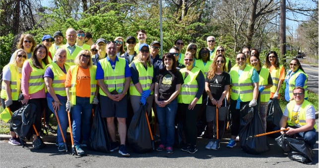 A team of Covanta employees beautifies a neighborhood by cleaning up trash